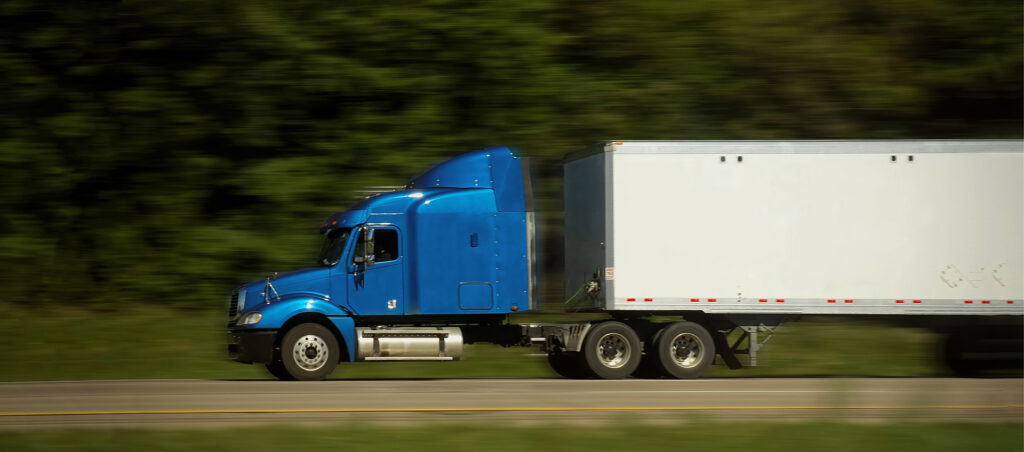 semi truck moving quickly down the highway